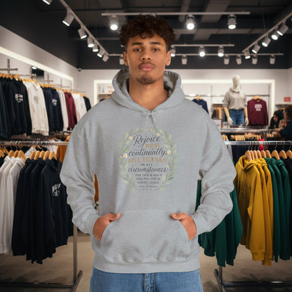 Man wearing a gray hoodie with Rejoice always pray continually give thanks 1 Thessalonians 5:16-18 in a store setting

